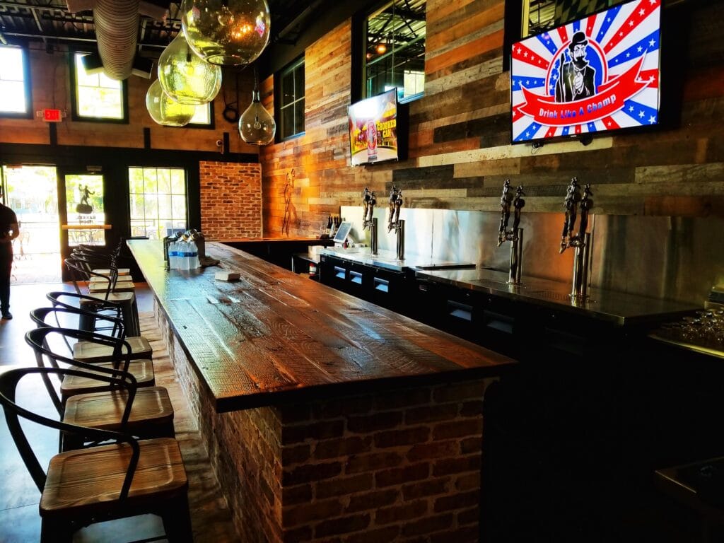 wood bar with barstools and four beer taps - crooked can brewing co winter garden florida